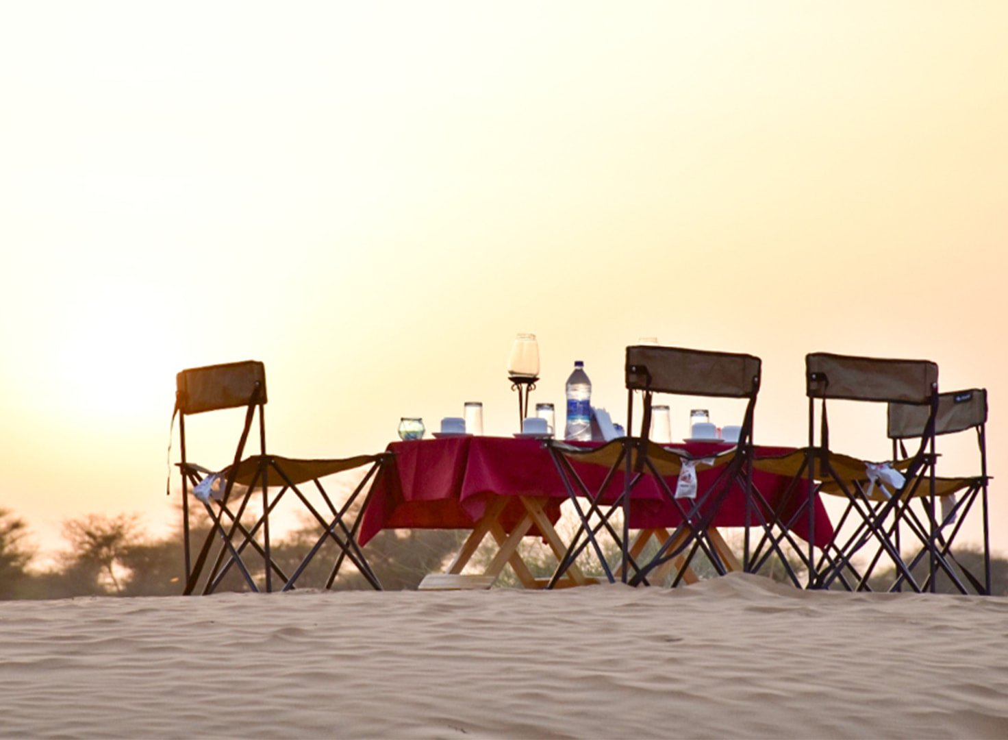 A table set on the dunes outside Churu at golden hour